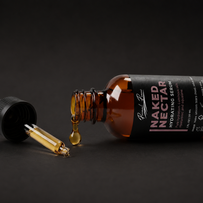 Naked Nectar serum bottle with dropper on a dark background